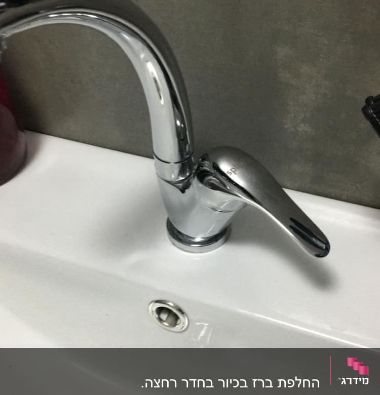 ברז כרום מותקן על כיור לבן עם ניקוז